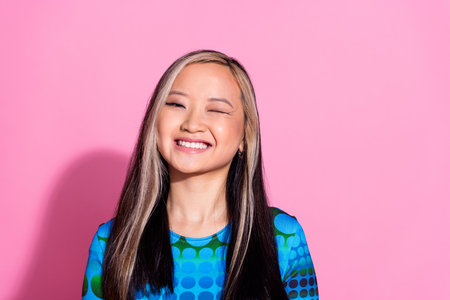 Photo of adorable lovely girl wear print top winking eye empty space isolated pink color background
