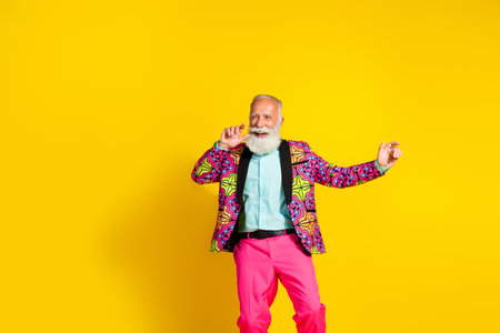 Photo of positive old man showman dancing have performance wear glamour clothes isolated yellow...