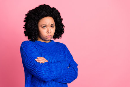 Portrait of sad upset lovely woman wear blue stylish clothes crossed arms isolated on pink color...