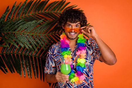 Photo portrait of nice young man touch sunglass enjoy summer palm leaves wear trendy colorful outfit isolated on orange color backgroundの写真素材