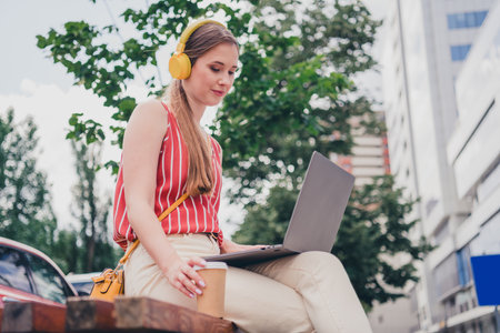 Photo of lovely girl blond hair dressed stylish clothes sitting outdoors using gadget laptop netbook weekendの写真素材