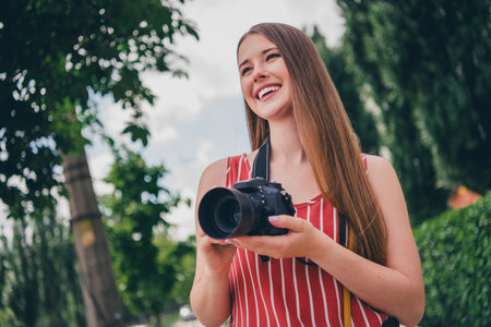 Photo of positive adorable girl wear trendy clothes photographing capturing taking pictures photos outdoorsの写真素材