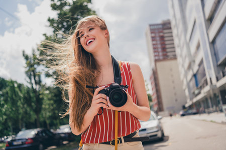 Photo of positive cute girl wear trendy clothes walk city center take picture summer weather...