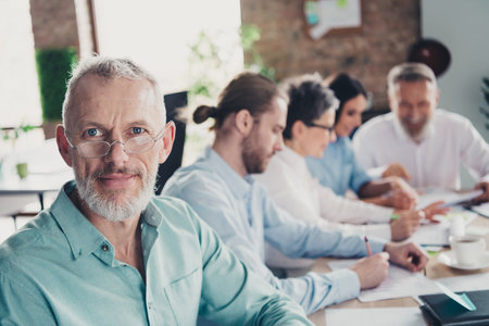 Photo of teamwork people working together mature man smile look camera comfortable modern office...