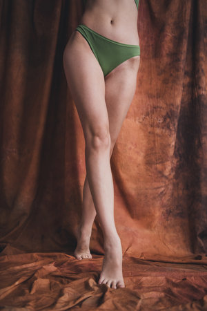 Photo no filter of young model wearing invisible tights posing in studio over brown color backgroundの写真素材