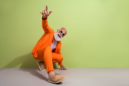 Full size portrait of modern grandfather empty space clothes shoes ad isolated on green color backgroundの写真素材