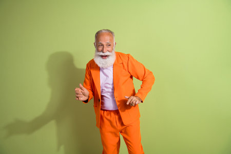 Photo of good mood nice man wear stylish suit enjoy weekend party isolated on green color backgroundの写真素材