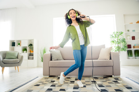 Photo of good mood positive lovely girl dance sing have fun comfortable apartment flat living room daylight indoorsの写真素材