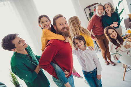 Photo of big family playing together have fun piggyback celebrate holiday dinner multi-generation...