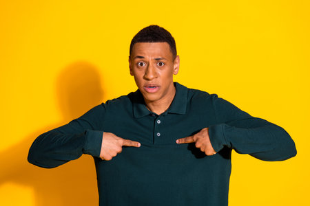 Photo of nice young man point fingers self wear pullover isolated on bright yellow color backgroundの写真素材