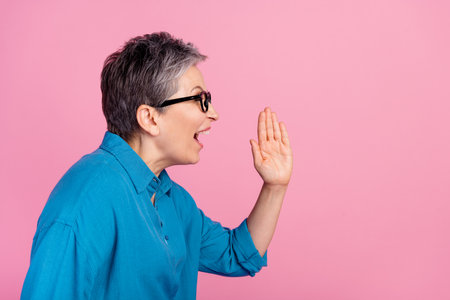 Photo portrait of pretty retired female share secret scream wear trendy blue outfit isolated on pink color backgroundの写真素材
