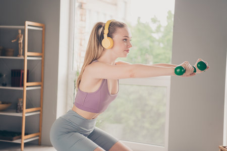 Photo of sporty active energetic strong girl training at home doing physical exercises house indoors