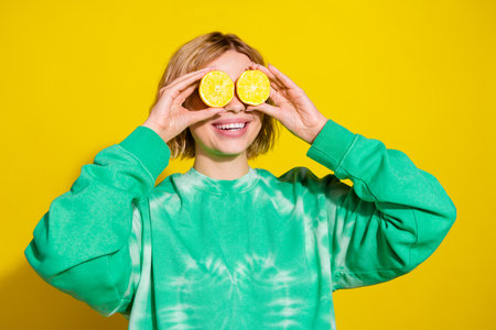 Photo of shiny attractive lady dressed tie dye sweatshirt holding lemons cover eyes empty space...