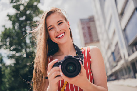 Photo of positive cute girl wear stylish clothes walk city center take picture summer weather...