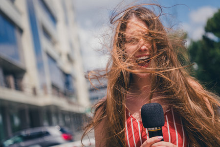 Photo of lovely funny nice woman journalist correspondent speaking in microphone television outdoorsの写真素材
