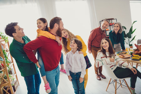 Photo of attractive cheerful big full family play together piggyback meeting eating holiday dinner...