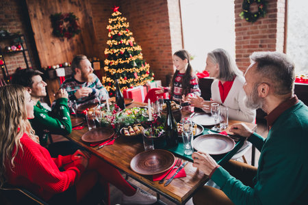 Photo of big full family talk eat food celebrate christmas festive time apartment indoorsの写真素材