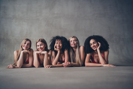 No retouch photo of group cheerful girls enjoy love and harmony self care concept isolated on concrete wall studio backgroundの写真素材
