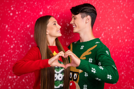 Photo of romantic affectionate couple in love show heart symbol wear ugly pullover isolated red...