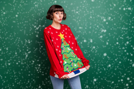 Photo of impressed charming young lady wear print sweater showing tree picture isolated green color backgroundの写真素材