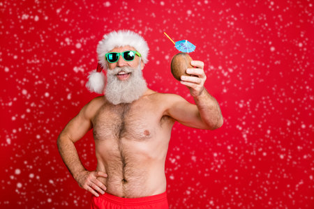 Portrait of his he nice attractive cheerful cheery funky gray-haired man enjoying leisure having fun drinking fresh tasty juice rest relax toast cheers isolated over bright vivid shine red backgroundの写真素材