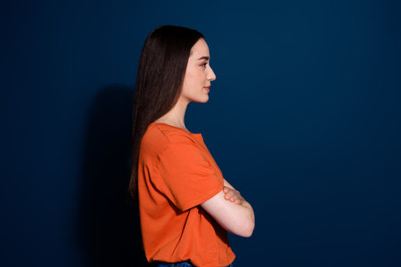 Photo of lovely cute nice young woman wear stylish clothes folded arms look empty space isolated on dark blue color backgroundの写真素材