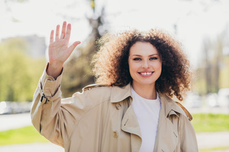 Photo of cheerful shiny girl dressed stylish beige trench enjoying spring sunny weather outdoorsの写真素材