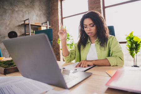 Photo of nice young woman office worker point finger read clipboard wear shirt loft interior business center indoorsの写真素材