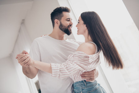 Portrait of two nice young people hug dance look each other bright interior free time apartment...
