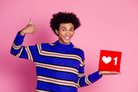 Photo of nice guy with wavy hair dressed knitwear sweater holding social media like show thumb up...