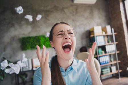 Photo of sad unhappy lady recruiter dressed shirt eyewear screaming indoors workplace workstation loftの写真素材
