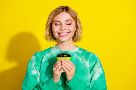 Photo of charming positive woman wear green sweatshirt enjoy coffee aroma empty space isolated...