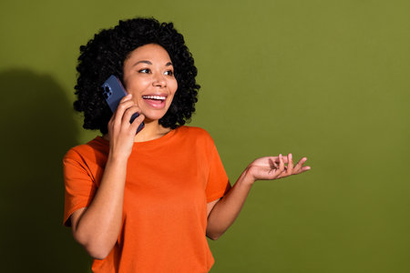 Photo portrait of lovely young lady talk phone look empty space dressed stylish orange garment...