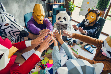 Photo of rooster gorilla lion panda sloth zebra raccoon mask people desktop meeting touch hands...