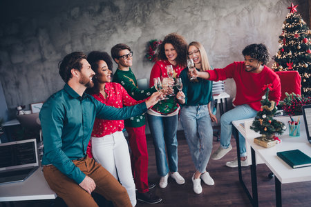 Full length photo of attractive young people drink toast alcohol employees new year decoration interior corporate party officeの写真素材