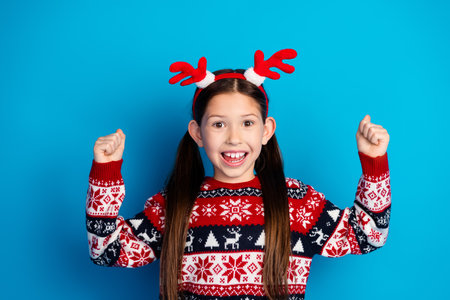 Photo of cheerful positive girl wear red sweater christmas festive event hand fist isolated on blue color backgroundの写真素材