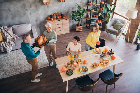 High angle view photo of four relatives family prepare baked chicken gather celebrate thanksgiving dinner apartment indoorsの写真素材