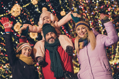 Portrait of attractive cheerful family having fun festal fair shopping sale strolling wearing warm...
