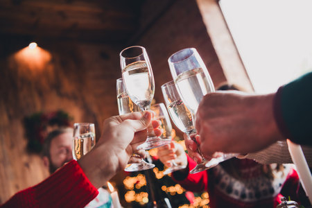 Cropped portrait of friendly peaceful family hands hold clink champagne gather celebrate new year xmas flat indoorsの写真素材