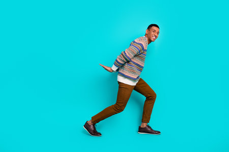 Full body portrait of nice young man hold empty space wear pullover isolated on turquoise color...