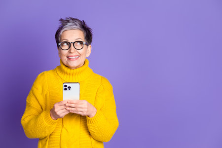 Photo of charming positive woman wear yellow sweater texting modern device looking empty space...