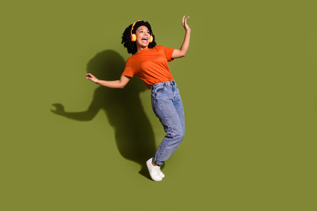 Full body portrait of nice young woman dancing empty space wear t-shirt isolated on khaki color...