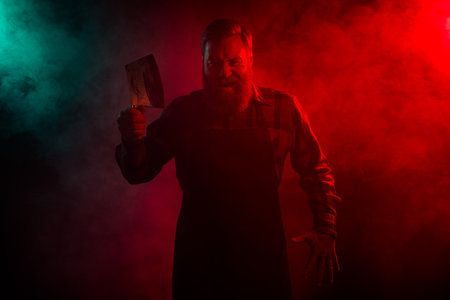 Photo of mysterious serious retired man butcher hold blade knife apron isolated dark red green neon...