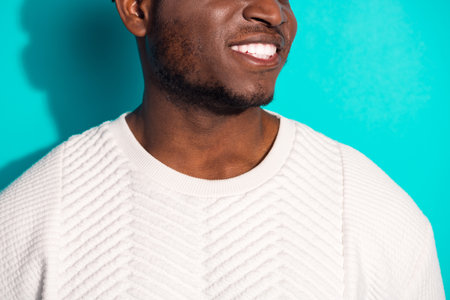 Cropped photo of attractive young man cheerful smile healthy smile dressed stylish white clothes isolated on cyan color backgroundの写真素材