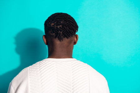 Photo portrait of handsome young guy back view hairdress barbershop neck dressed stylish white garment isolated on cyan color backgroundの写真素材