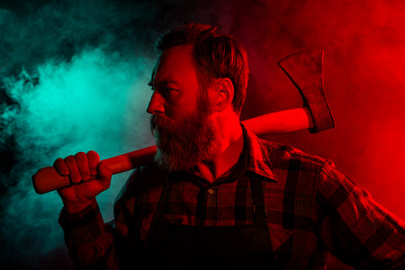 Photo of spooky creepy halloween male character hold sharp ax isolated on dark misty mysterious...