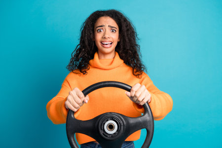 Photo of pretty young girl hold wheel wear orange pullover isolated on teal color backgroundの写真素材