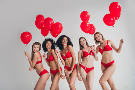 Photo of young ladies people hold helium balloons dressed red lingerie white wall studio background no filter self acceptanceの写真素材