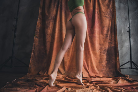 Photo of young sporty body lady wearing nylon tights no retouch in studio over brown color backgroundの写真素材