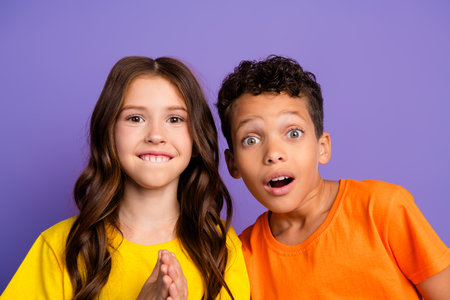 Photo of two impressed small kids open mouth wear t-shirt isolated on violet color background